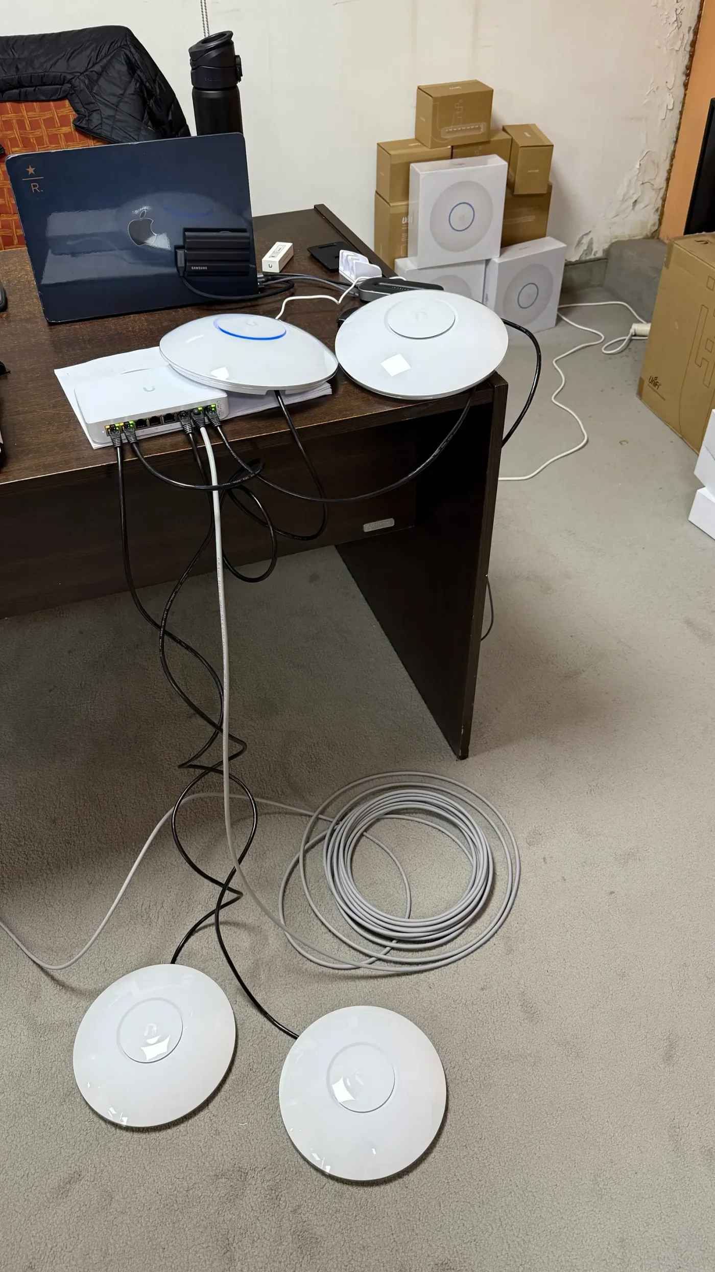Access points UniFi sobre un escritorio, listos para instalar en las habitaciones
